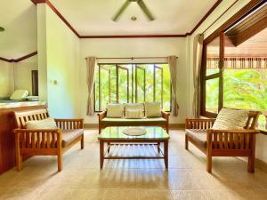 ein Wohnzimmer mit zwei Stühlen und einem Tisch in der Unterkunft Villa Mona-Beachfront Sunset Peaceful Garden Villa in Nathon Bay