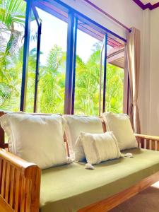 ein Sofa mit Kissen vor dem Fenster in der Unterkunft Villa Mona-Beachfront Sunset Peaceful Garden Villa in Nathon Bay + 25 Fotos