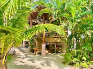 ein Resort mit Palmen vor einem Gebäude in der Unterkunft Villa Mona-Beachfront Sunset Peaceful Garden Villa in Nathon Bay