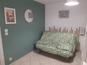 un divano in una camera con parete blu di studio bas de villa, jardin et spa (été seulement) a Le Tignet