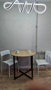 a table with two chairs and a chandelier at 1 комнатные апартаменты in Semey