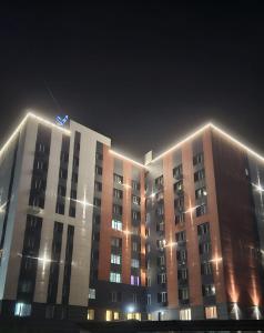 a building with lights on top of it at night at 1 комнатные апартаменты in Semey