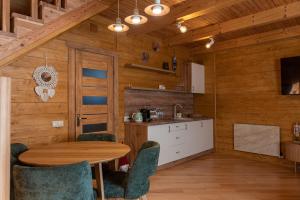 a kitchen with a table and chairs in a cabin at Zolota Forel Hotel in Korostov