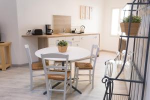 cocina con mesa blanca y sillas en Grand studio République, en LʼIsle-sur-la-Sorgue