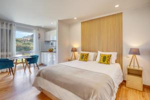 a bedroom with a large bed and a table and chairs at Quinta da Vila in Porto da Cruz