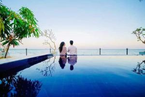 a man and a woman standing next to a swimming pool at Lagoon Bay Resort in Negombo