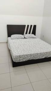 a bed in a room with a white floor at Homestay Afiqah in Malacca +4 photos