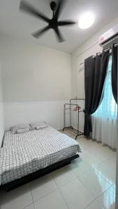 a bedroom with a bed and a ceiling fan at Homestay Afiqah in Melaka
