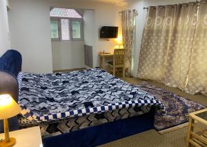 a bedroom with a blue bed and a window at Al Jalal in Srinagar