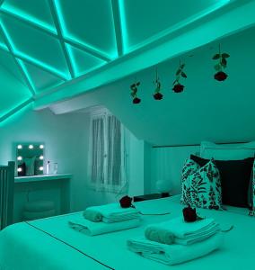 a blue room with a bed with towels on it at La Suite Prestige - Jacuzzi et cinema - Cergy-Village in Cergy