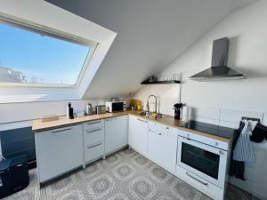 eine Küche mit weißen Schränken und einem großen Fenster in der Unterkunft 23-schöner Wohnen, großes Apartment für 5-6 Personen in super Lage in Duisburg