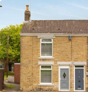 a brick house with a window and a door at Nelson 2 Double bedrooms 1 bathroom in Crook