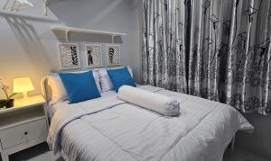 a bedroom with a large bed with blue pillows at The Jarrdin Apartment Cihampelas by NEMUI ROOM in Bandung