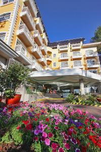 a large building with flowers in front of it at Hotel Elizabeth - Baguio in Baguio