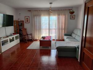 a living room with a couch and a tv at Lourdes 1 casa compartida solo con la anfitriona in Breña Baja