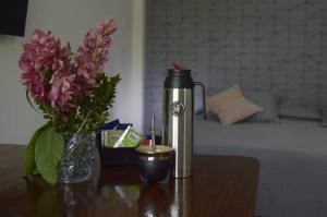 a thermos and a vase of flowers on a table at Monoambiente Eldorado 2 in Eldorado +19 photos