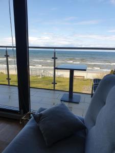 a living room with a table and a view of the ocean at Apartament Marzanna w Willi na Klifie in Rewal