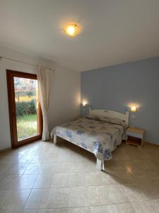 a bedroom with a bed and a sliding glass door at Seaview Apartment (N°23) in Porto Pozzo