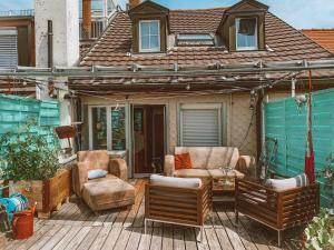 a patio with two chairs and a table and a house at Central city apartment with terrace in St. Gallen