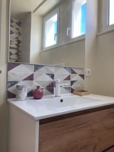 a bathroom with a white sink and a mirror at Chez Patrick et Virginie in Pont-Aven