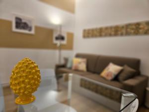 a living room with a glass table with a yellow vase on it at Appartamento XII Gennaio 3 in Palermo