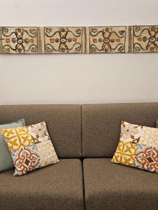a brown couch with two pillows on it at Appartamento XII Gennaio 3 in Palermo