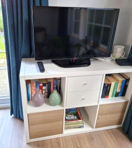 un centro de entretenimiento blanco con televisión. en De Perenboom, en Westkapelle 27 fotos más
