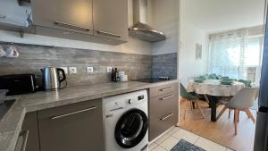 a kitchen with a washing machine and a table at Appartement les Capucins ROSCOFF in Roscoff +19 photos
