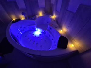 a blue tub in a room with lights at La Cachette des Murmures- Balnéo Privée I Détente in Boulogne-sur-Mer +32 photos