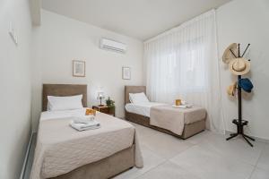 a bedroom with two beds and a window at Anchora in Paralimni +31 photos