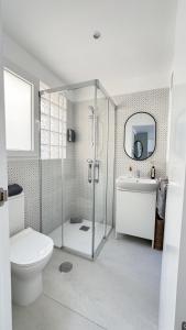 een badkamer met douche, toilet en wastafel bij RYAP Puerta Real in Granada +29 foto's