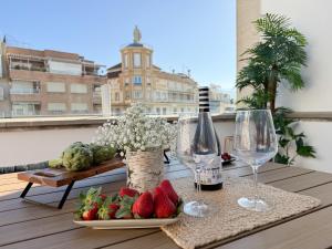 a table with wine glasses and strawberries on a balcony at RYAP Puerta Real in Granada