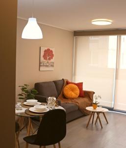 a living room with a couch and a table at Hermoso Departamento a pasos de Movistar Arena in Santiago