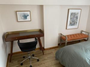 einen Schreibtisch in einem Schlafzimmer mit einem Bett und einem Schreibtisch in der Unterkunft Little Cottage - A Peaceful 3BD Retreat for 5 in Chorley
