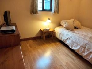 a bedroom with a bed and a table with a lamp at Herdsman's Hideaway in Leominster +10 photos