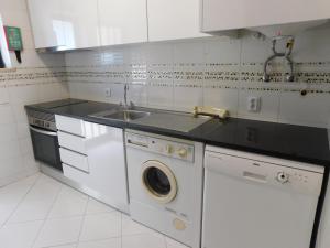 une cuisine avec un évier et une machine à laver dans l'établissement Sol Nascente Garden, à Vilamoura