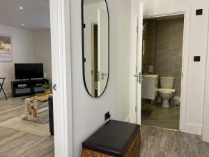 a bathroom with a mirror and a stool in a room at Town Centre Two-Bedroom in Swindon