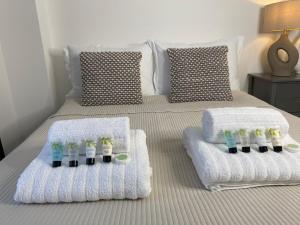 a bedroom with two beds with towels and toothbrushes at Town Centre Two-Bedroom in Swindon +18 photos
