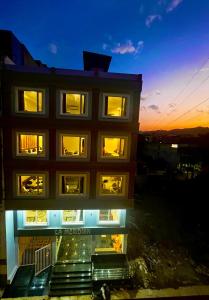 un edificio con sus luces encendidas por la noche en Hotel LA Meridian - Rishikesh Road, Haridwar, en Rishīkesh