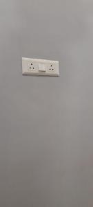 a white wall with a shelf on a white wall at Dreams Stay in Lucknow