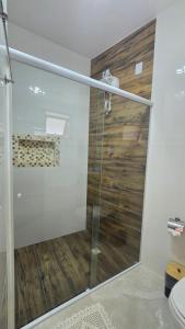 una ducha con puerta de cristal en un baño en Suite Pássaros, en Ilhabela