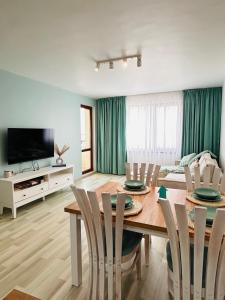 Una sala de estar con una mesa de comedor con sillas. en Infinity Blue Apartment-Complex Carpe Diem - FREE PARKING, en Balchik