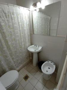 un baño con inodoro y lavabo en HOTEL APOLO NEUQUEN, en Neuquén