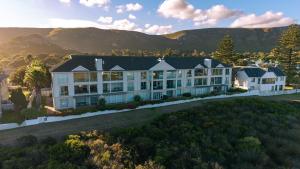 an aerial view of a large white building with mountains in the background at Seaside Serenity: Tranquil Oceanview Retreat in Hermanus