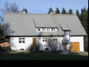 une maison blanche avec un toit gris dans l'établissement Ferienwohnung Schartenschmiede, à Sankt Georgen im Schwarzwald