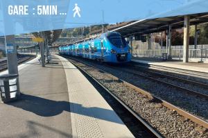 a blue train is pulling into a train station at FactoryLoftCosy Gare à 5mins in Bellegarde-sur-Valserine