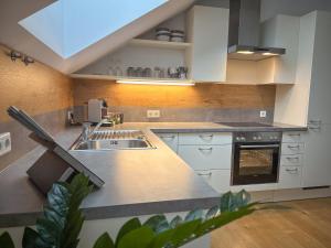 a kitchen with white cabinets and a sink at "EIGHT" Premium Apartments Seekirchen, charmante 3-Zi-Dachgeschoss-Wohnung mit Balkon in Seekirchen am Wallersee +42 photos