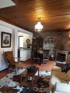ein Wohnzimmer mit einem Steinkamin und einem Tisch in der Unterkunft Casa da Laura - Um refúgio na Serra da Estrela in Alvoco da Serra