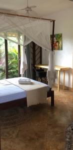 Bett mit Baldachin in einem Zimmer mit Tisch in der Unterkunft Villa Cajuiero Inn in Prea