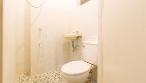 a white bathroom with a toilet and a shower at RedDoorz at La Maria Pension And Tourist Inn in Cebu City +25 photos
